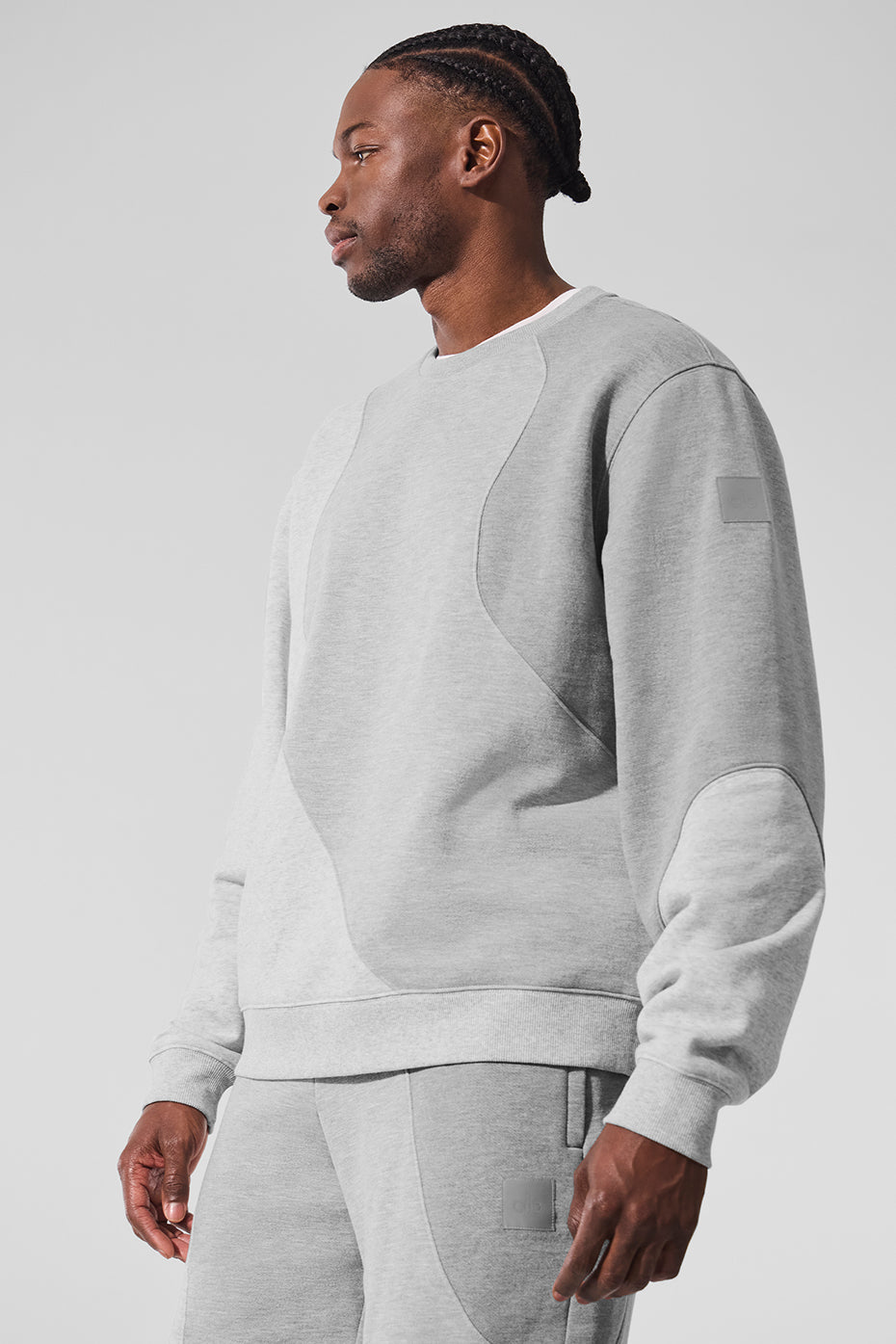 Front view of black crew neck pullover styled with matching sweatpants