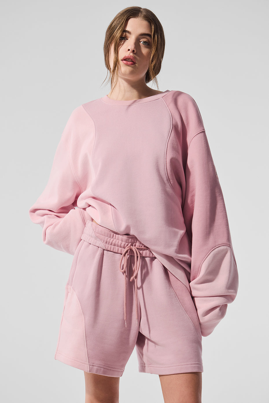 Front view of oversized crew neck pullover in tonal pink on model