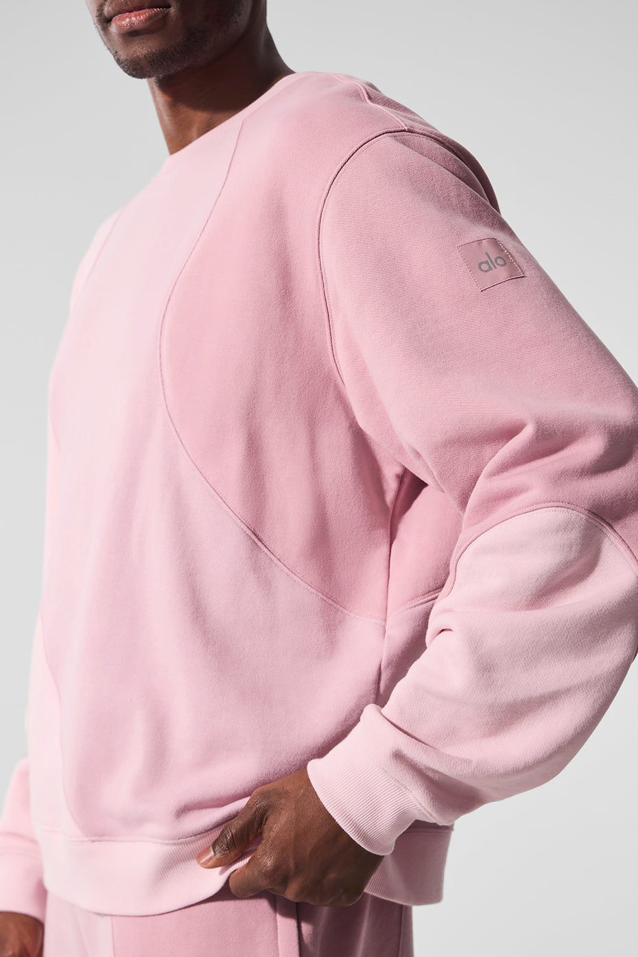 Model lounging in the oversized crewneck sweatshirt paired with sweatpants.
