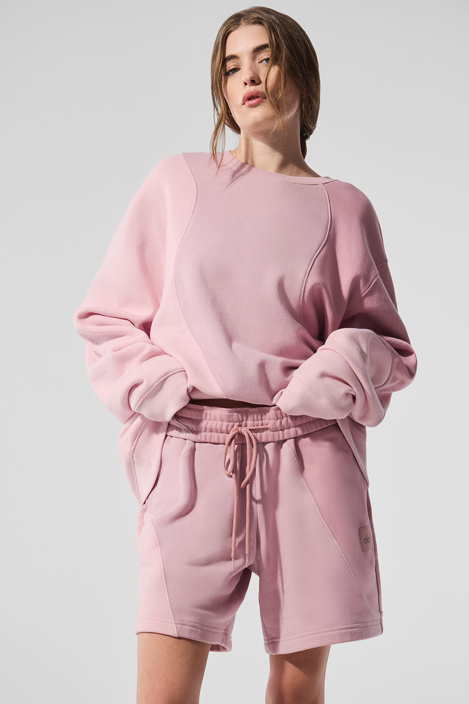 Front view of oversized crew neck pullover in tonal pink on model