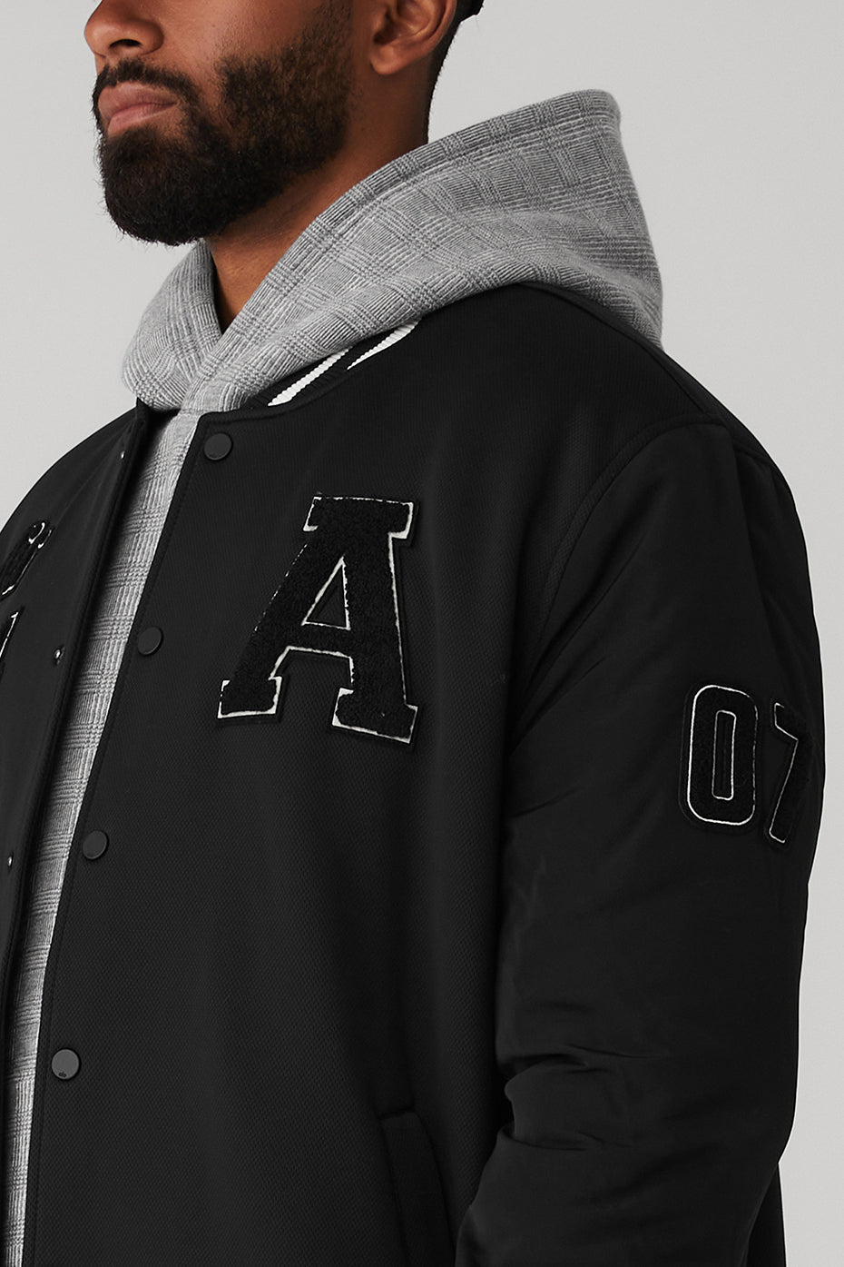 Front view of the G.O.A.T varsity jacket with patches and zip closure