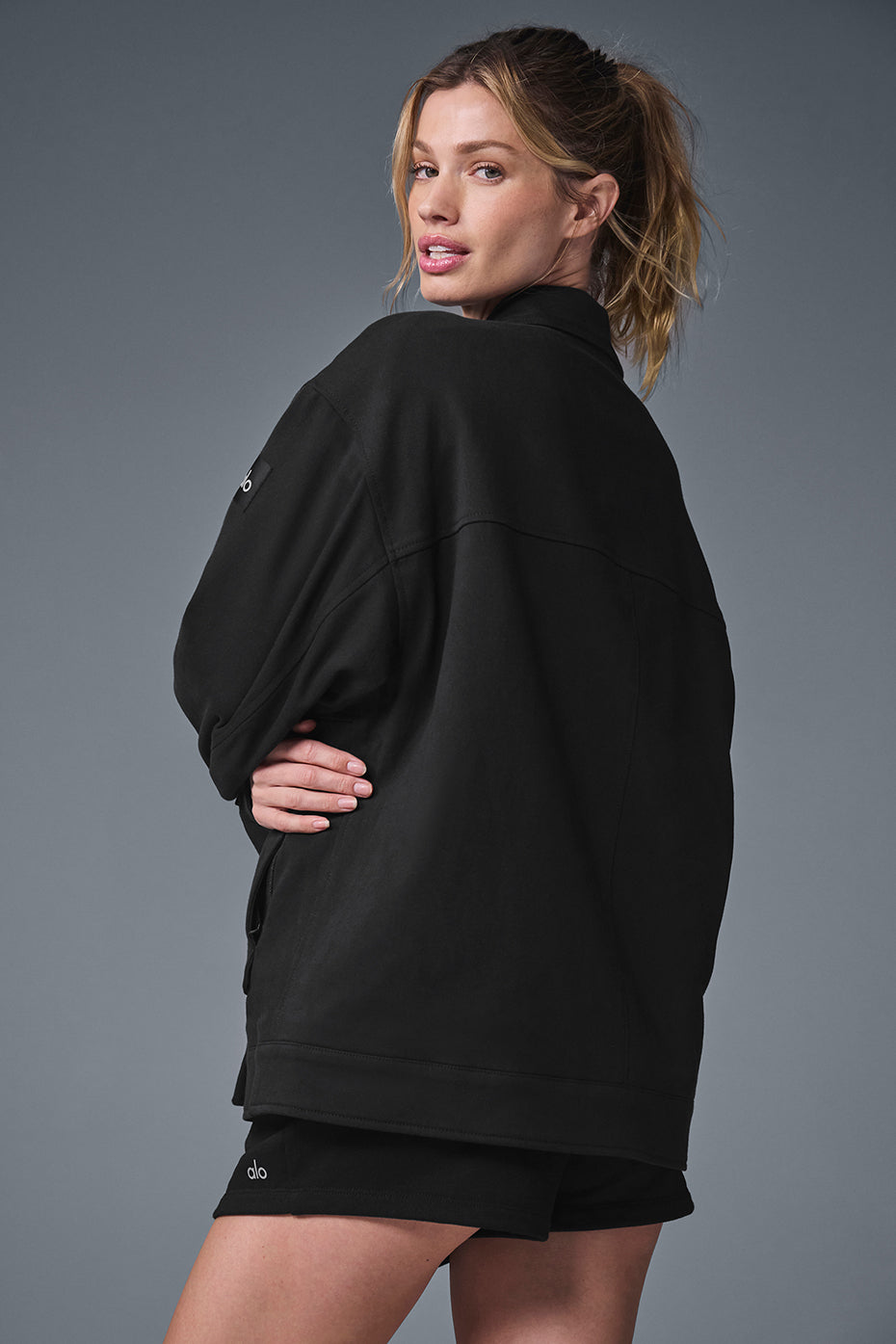 Side view showing the jackets oversized pockets and boxy silhouette on a male model