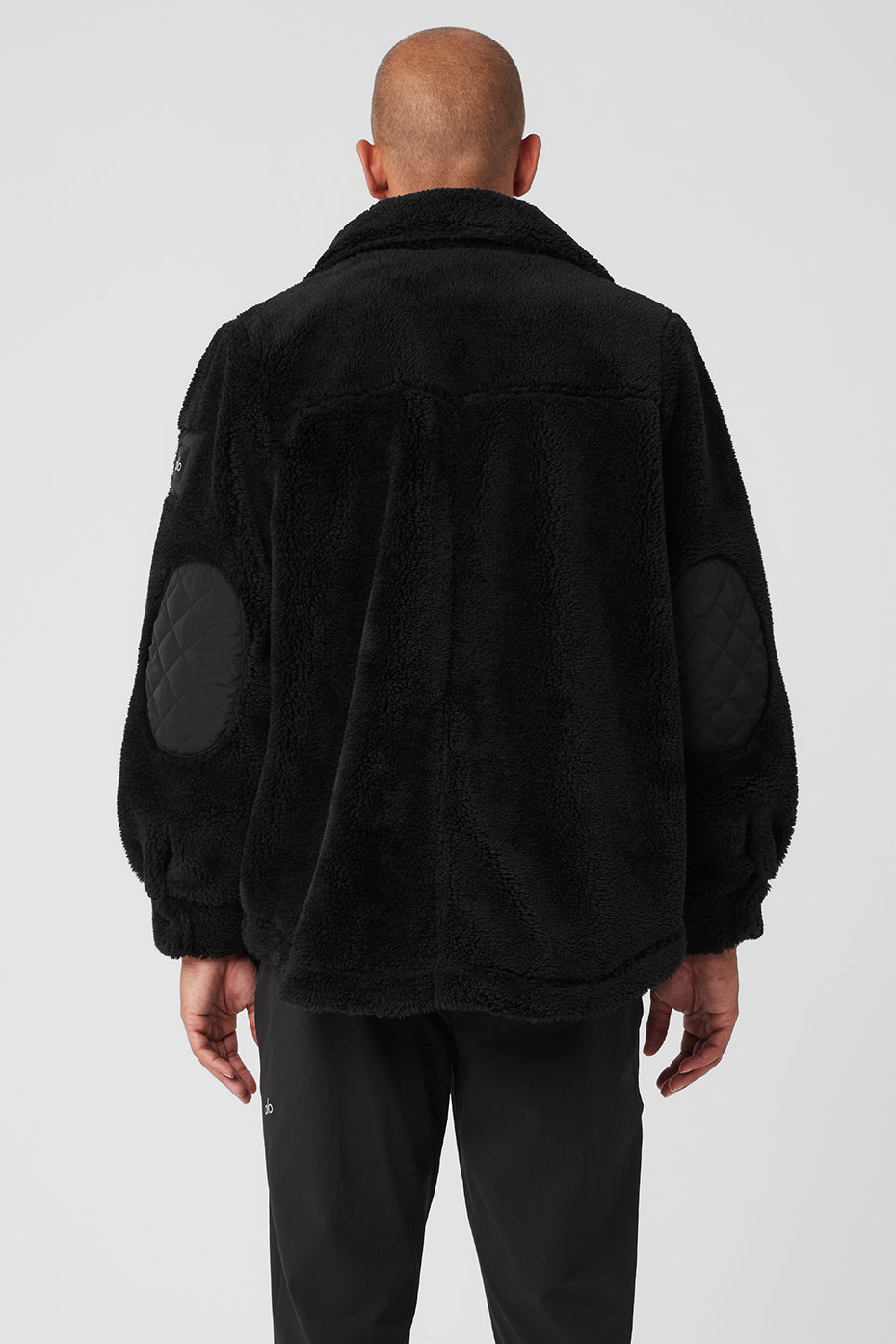 Close-up of quilted flap pockets on the black shacket for added style.