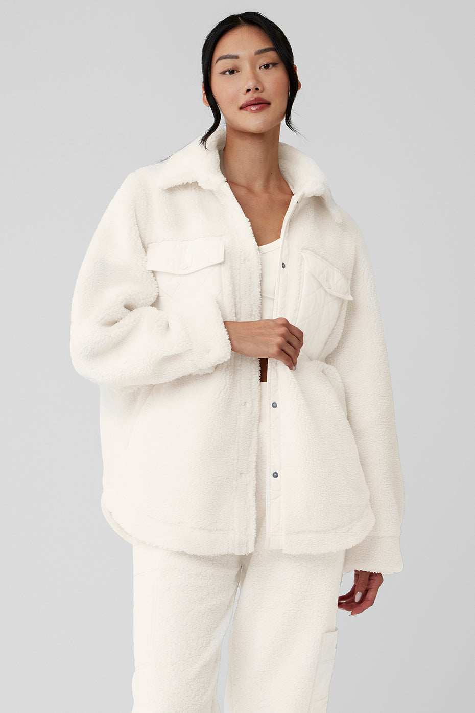 Close-up of ivory sherpa shacket fabric texture and snap closure