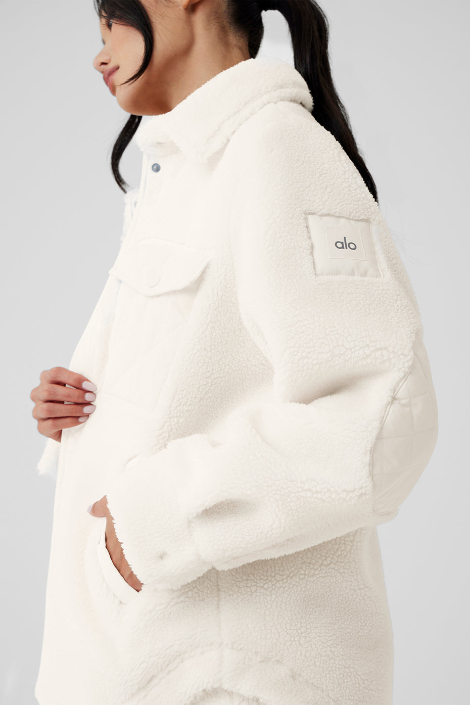 Close-up of ivory sherpa shacket fabric texture and snap closure