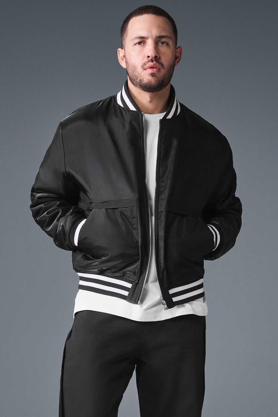 Front view of the Elevate Varsity Jacket in black, showcasing its stylish design.