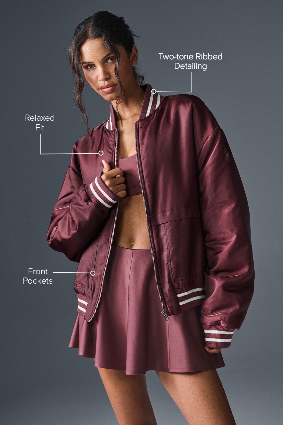Model wearing the varsity jacket outdoors in a casual street setting.