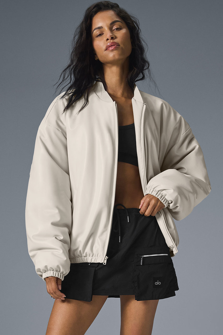 Front view of faux leather bomber jacket womens in bone color, styled with jeans