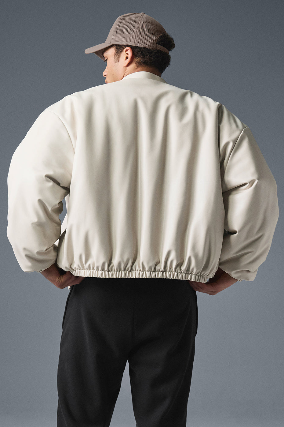 Side angle of the bone-colored bomber jacket showcasing its chic silhouette.