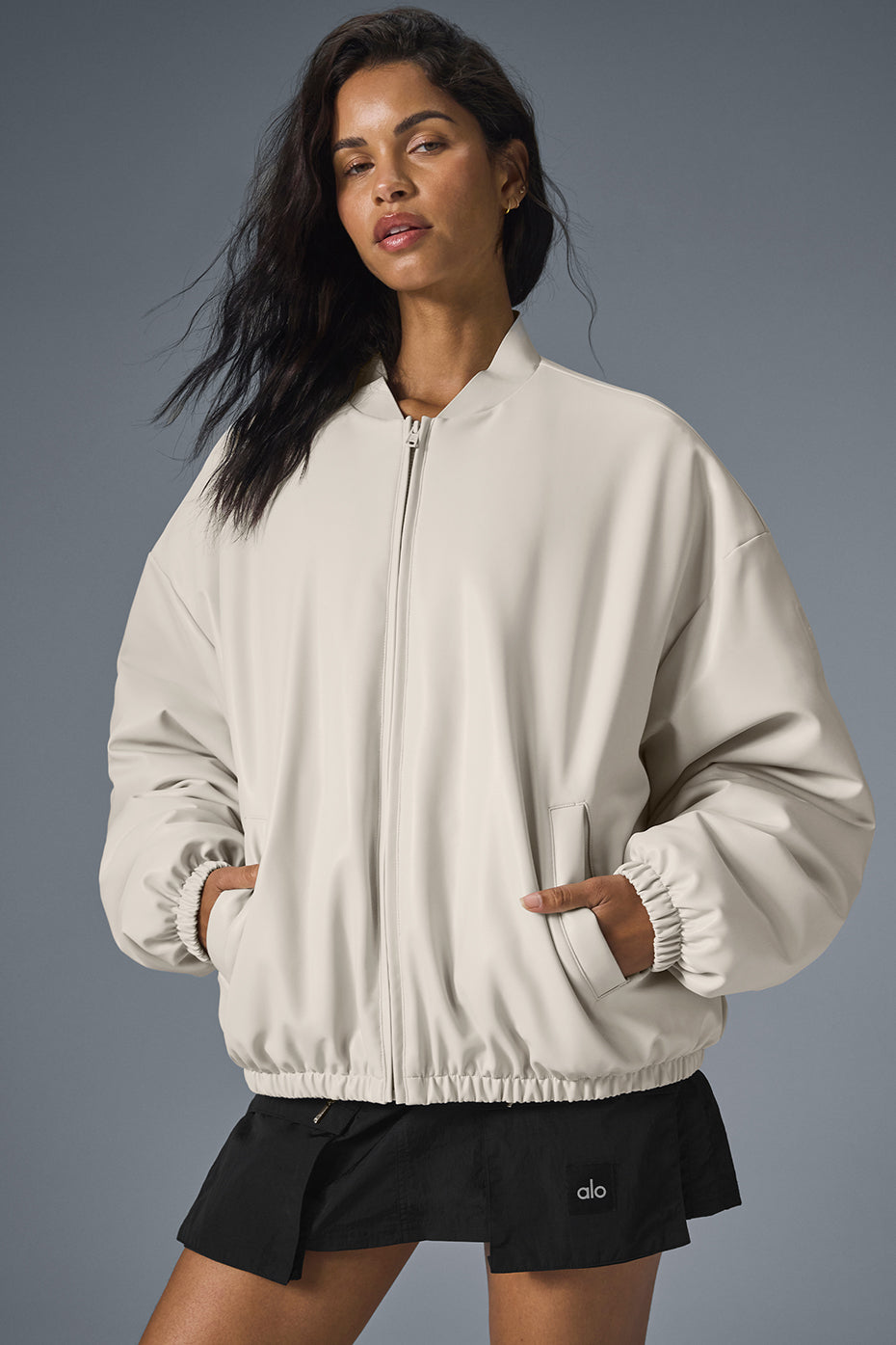 Front view of faux leather bomber jacket womens in bone color, styled with jeans