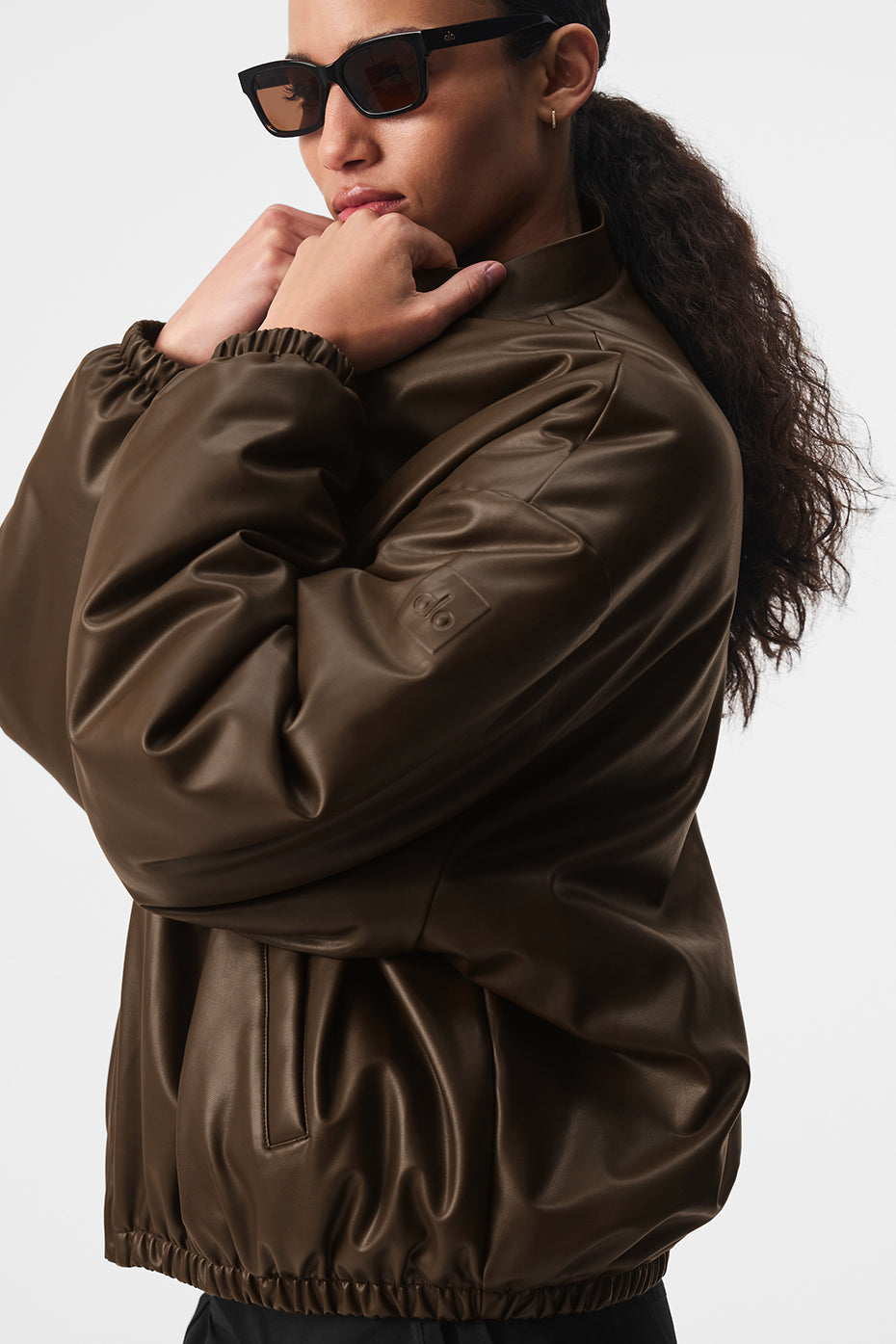 Close-up of the luxe faux leather texture on the bomber jacket.