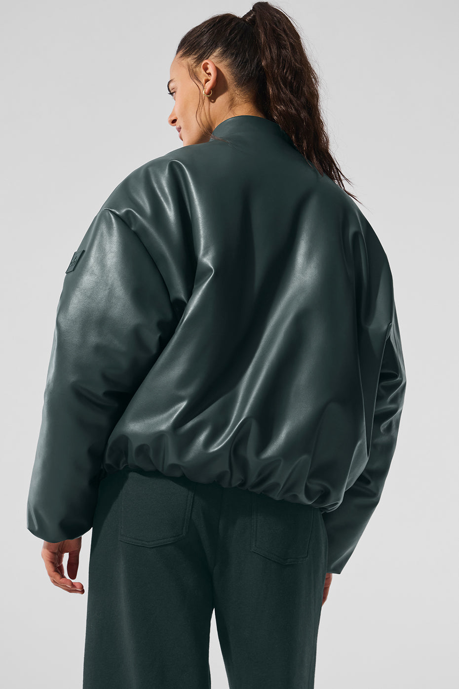 Model wearing the faux leather bomber jacket layered over a neutral sweater