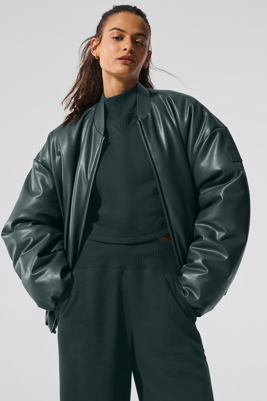 Close-up of the premium faux leather texture on the charcoal green bomber jacket