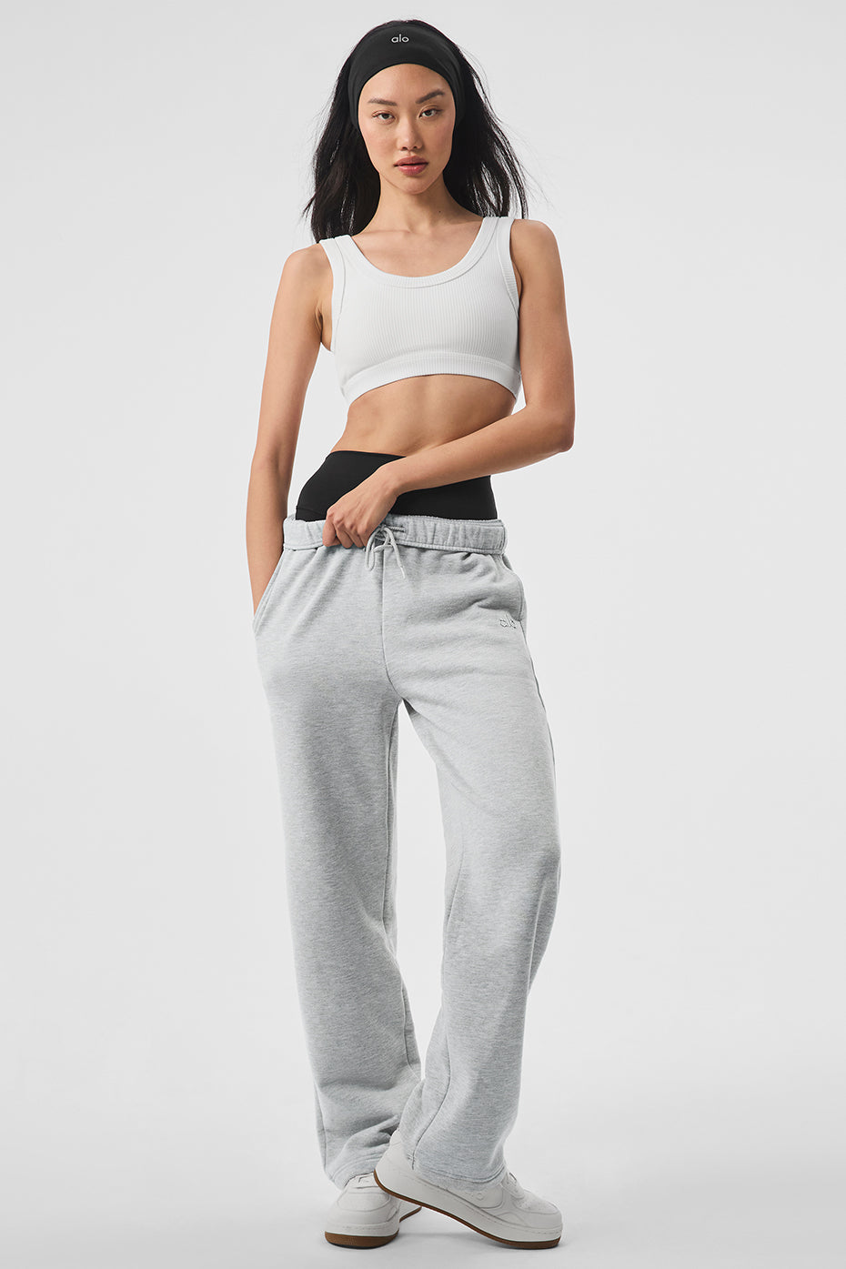 Model wearing straight leg sweatpants with sneakers on a downtown sidewalk