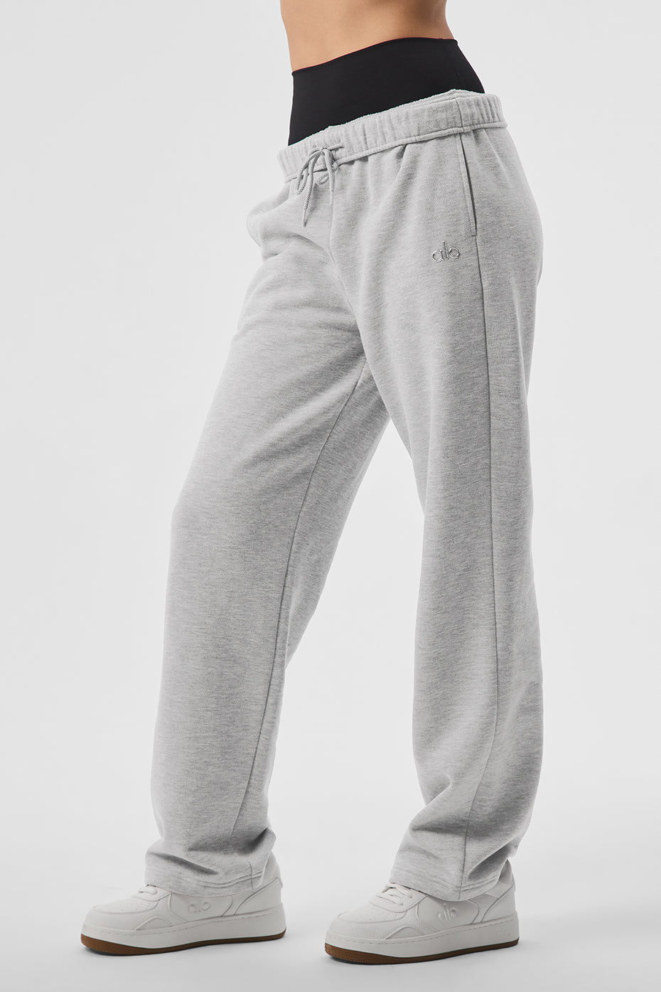 Model wearing straight leg sweatpants with sneakers on a downtown sidewalk