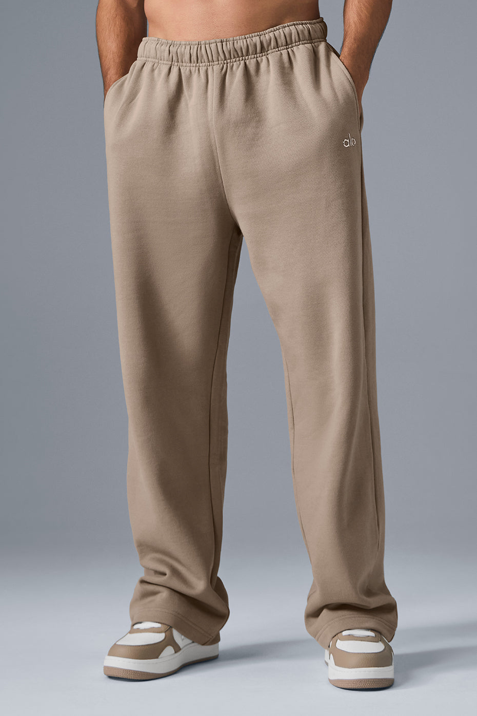 Front view of Accolade wide leg sweatpants in gravel, showcasing the chrome logo.