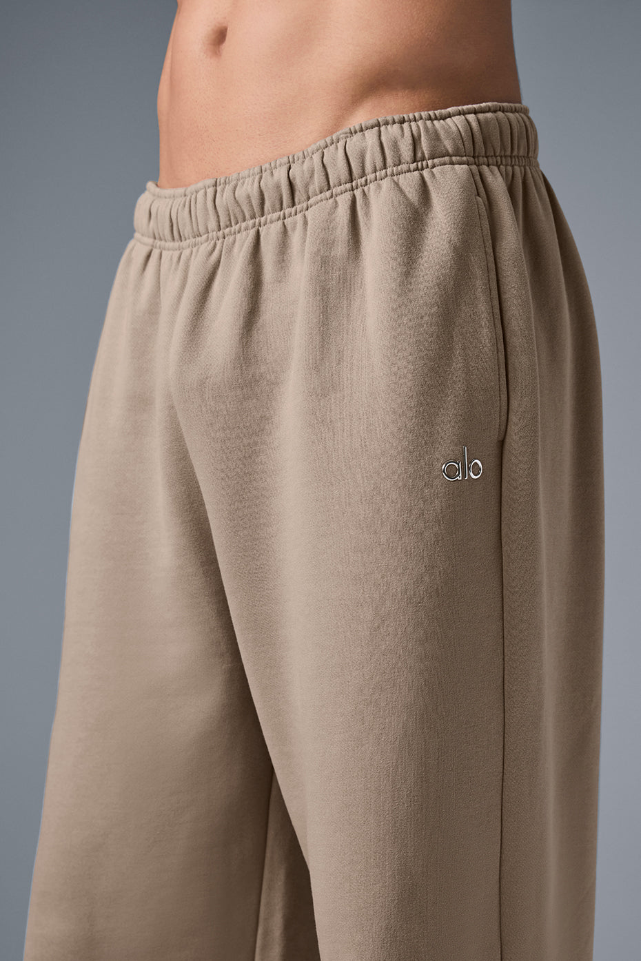Front view of Accolade wide leg sweatpants in gravel, showcasing the chrome logo.