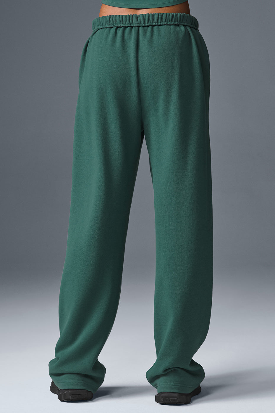 Close-up of wide leg sweatpants detail and chrome logo accent