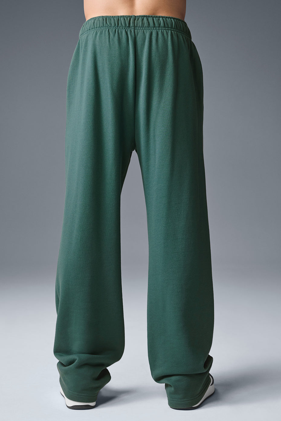 Side view of mens athleisure pants, highlighting the chrome ALO logo detail.