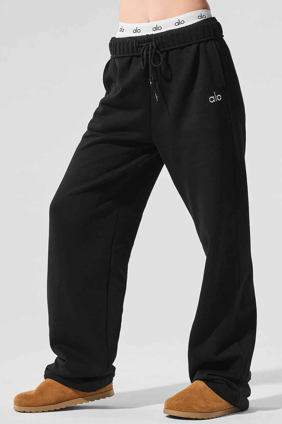Close-up of Accolade black sweatpants showcasing the chrome logo.