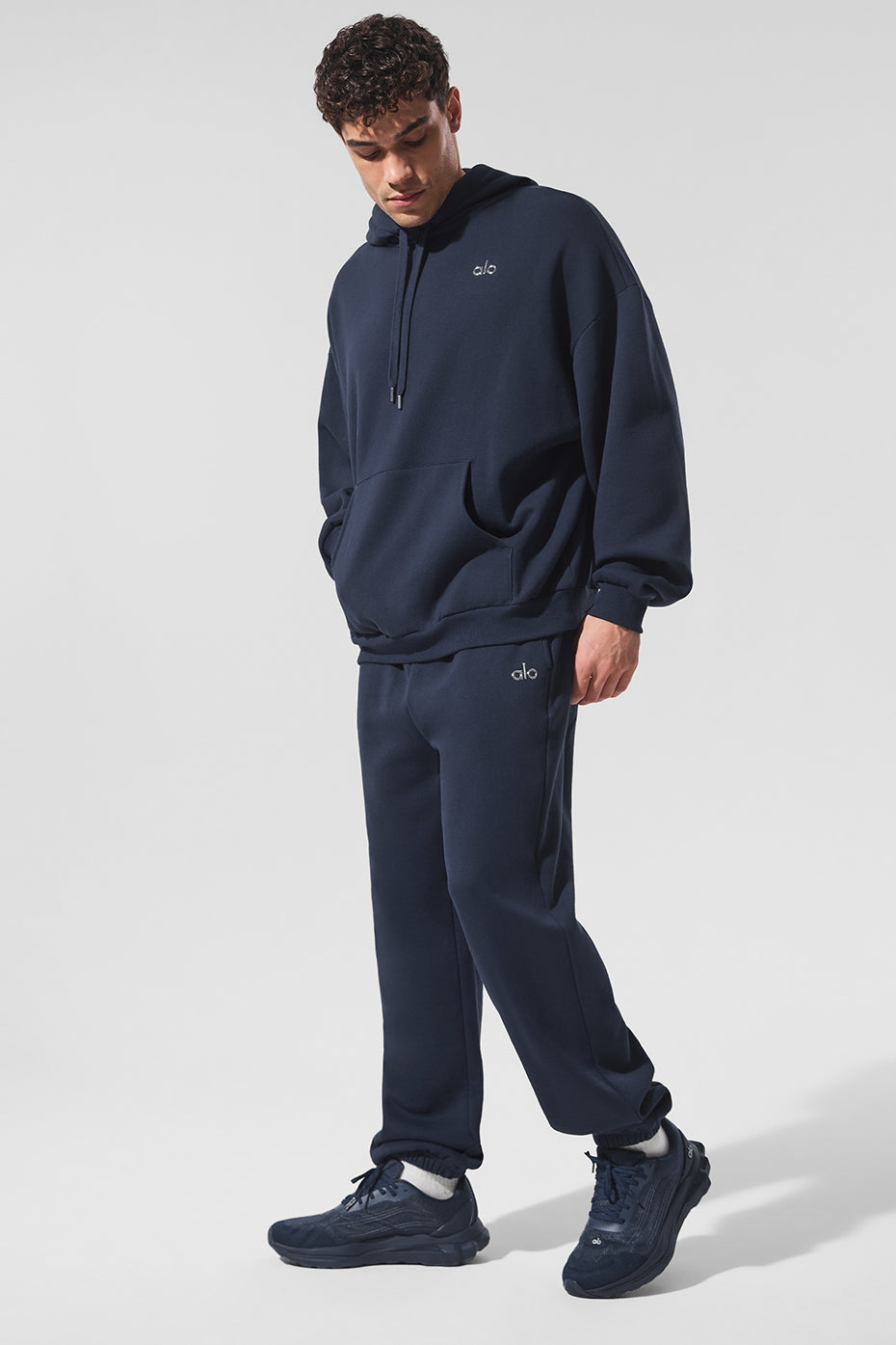 Model wearing navy joggers in a casual outdoor setting.