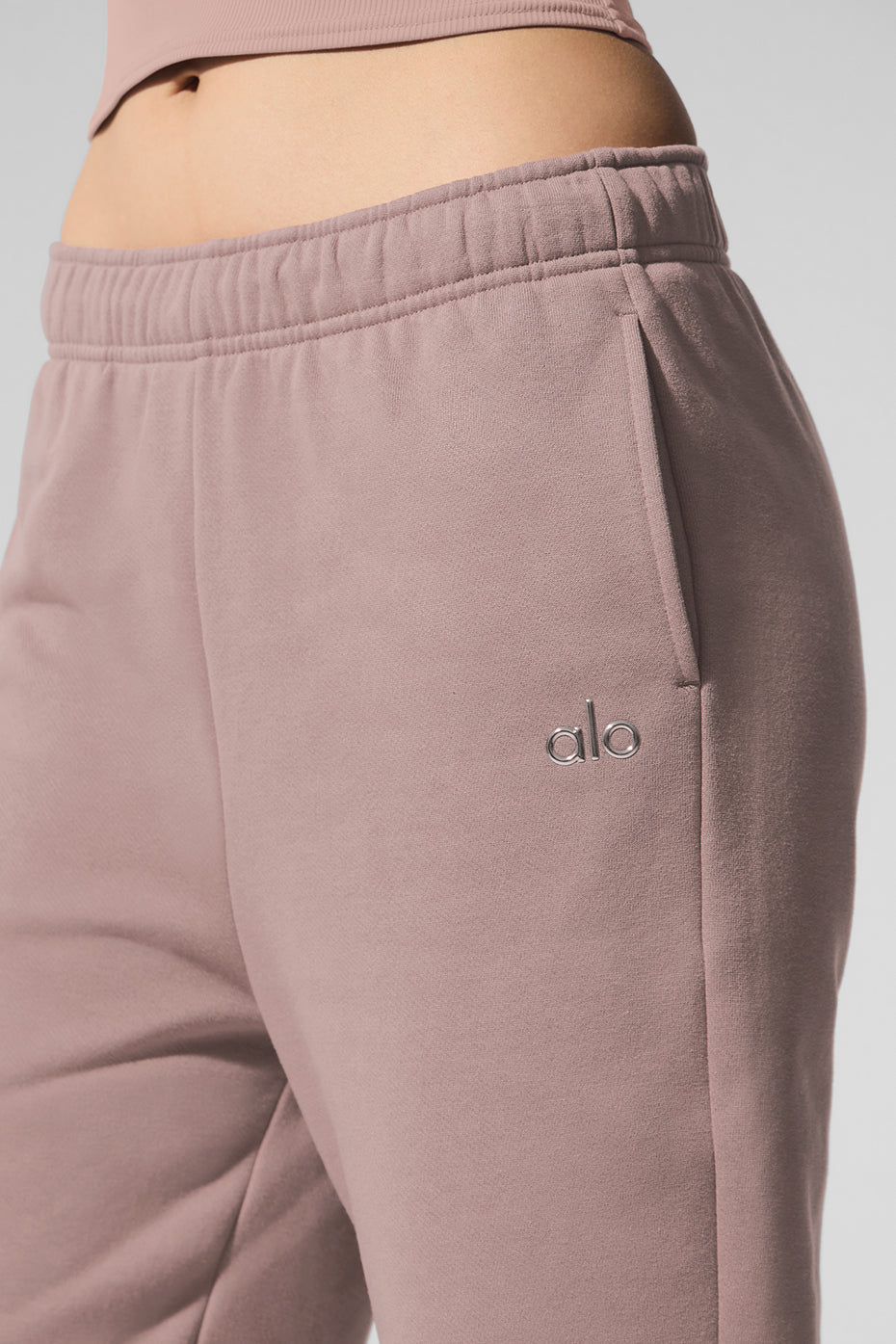 Close-up of waistband and cuffs on taupe sweatpants showing French terry texture.