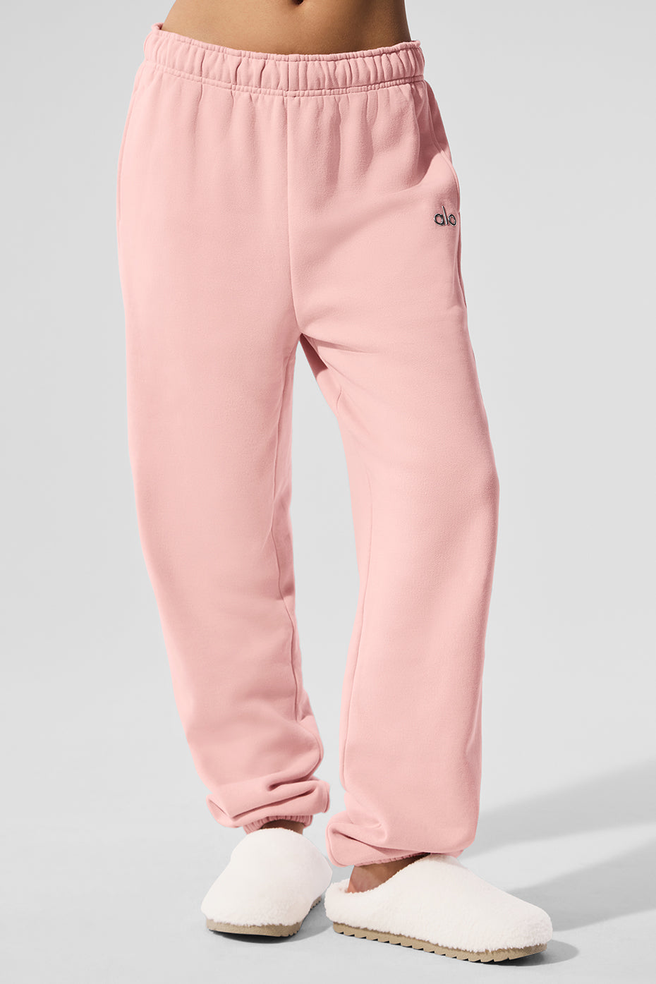 Model styling wide leg sweatpants with oversized sweater in urban setting