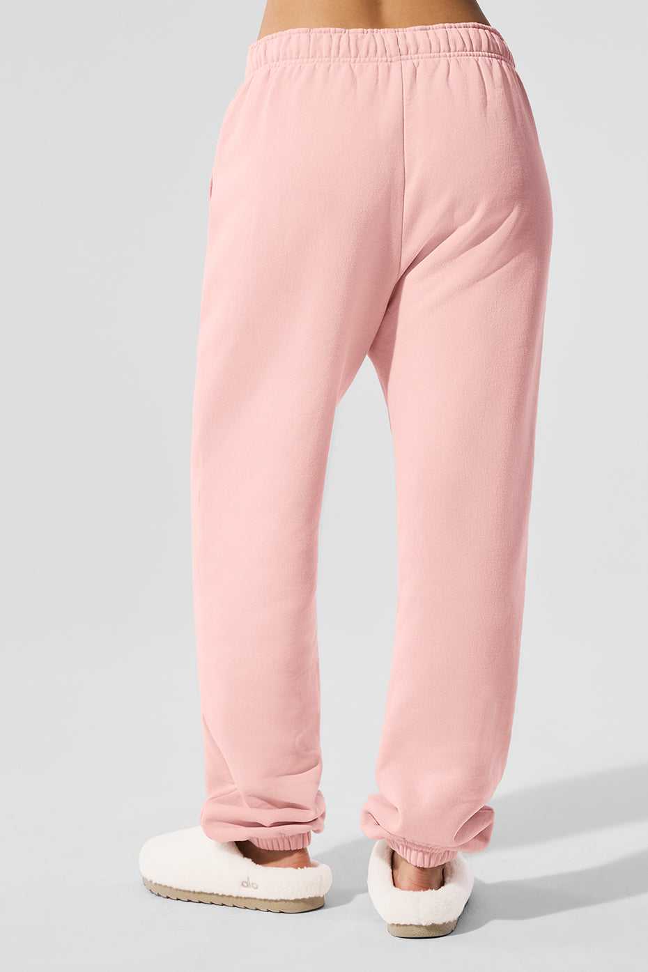 Model styling wide leg sweatpants with oversized sweater in urban setting
