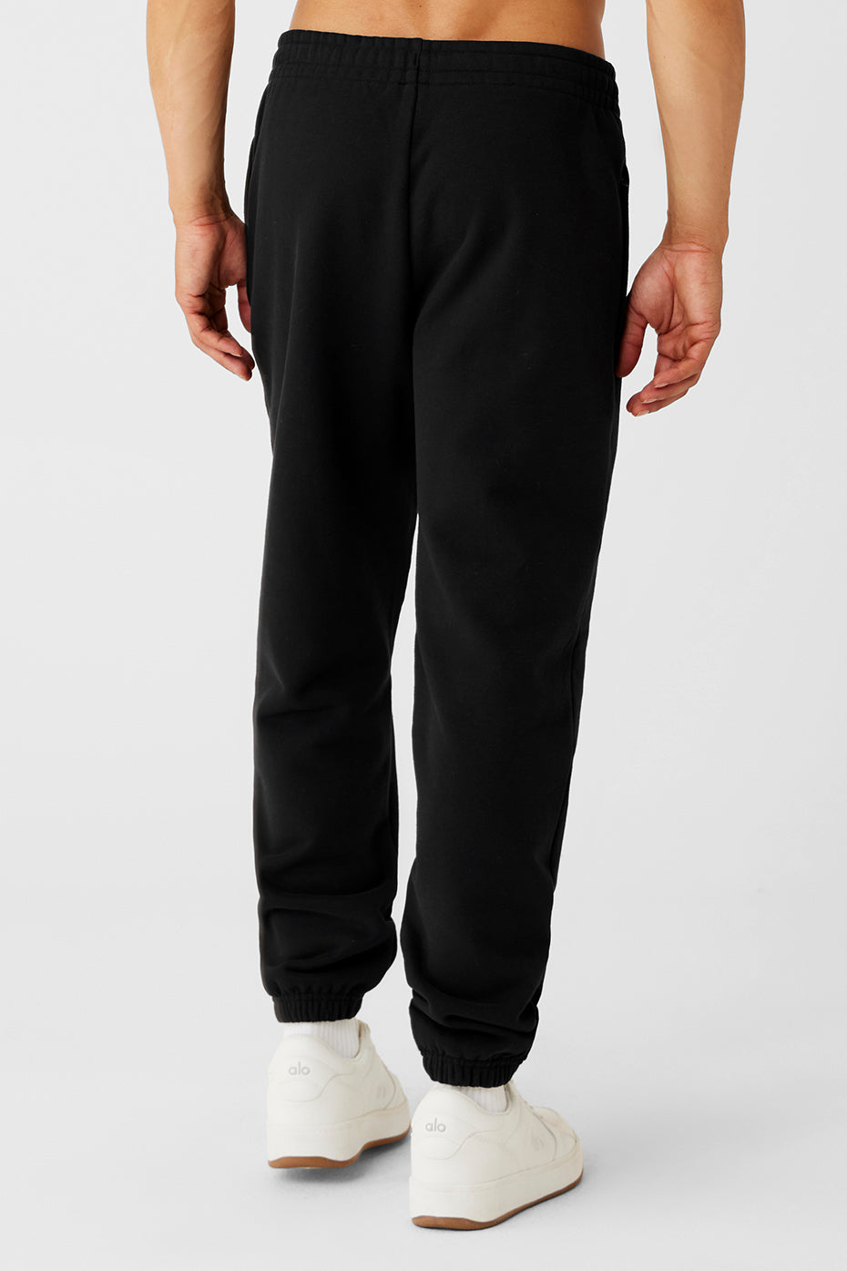 Side view of the cuffed sweatpants highlighting the zip-up pockets and relaxed fit.