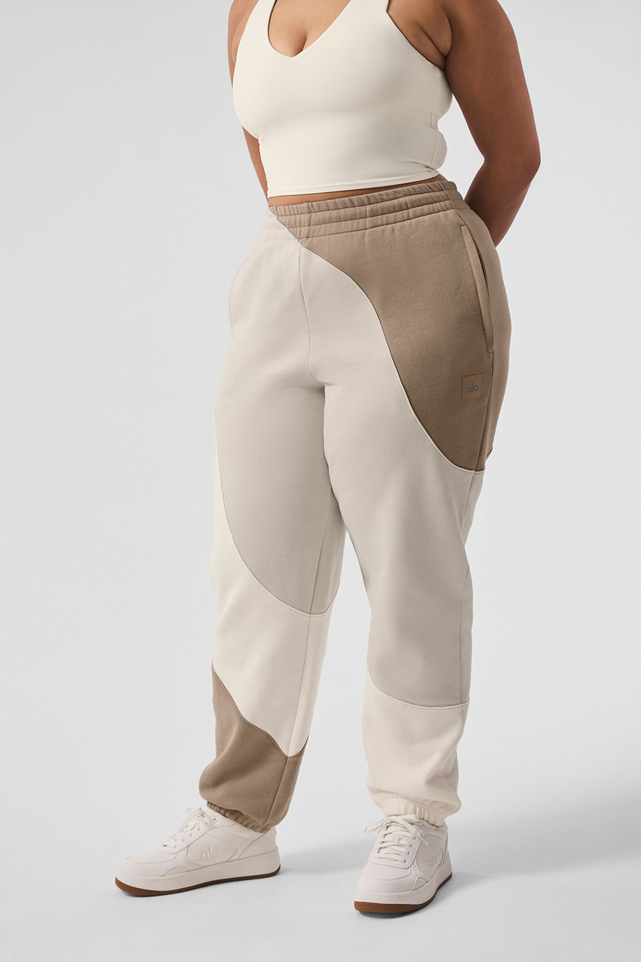 Wave stitch grey sweatpants folded on wooden bench with coffee cup