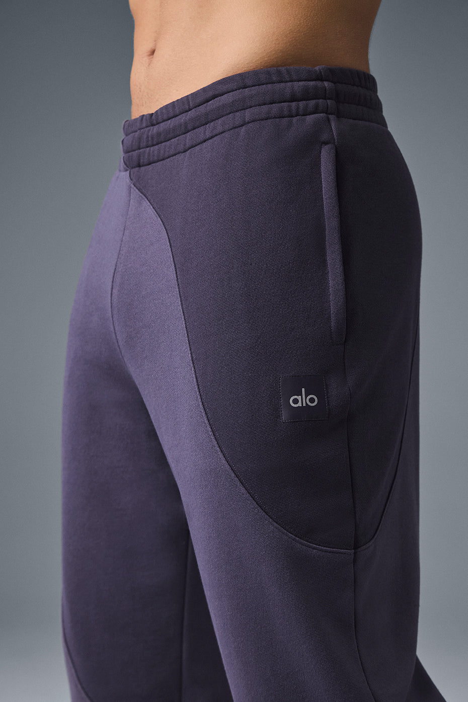 Front view of plum wave pattern sweatpants for women on model lounging indoors.