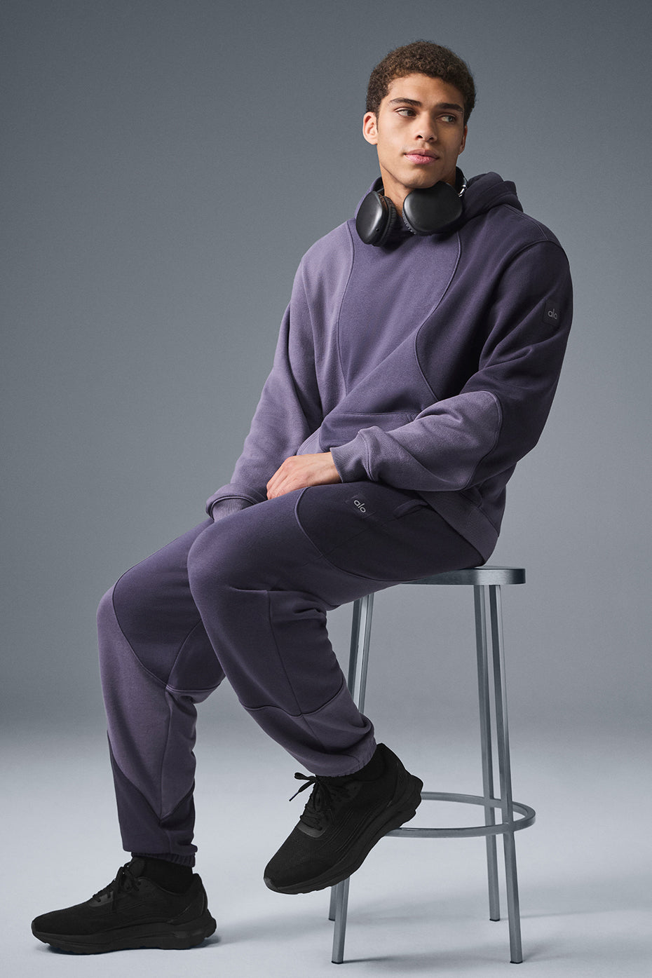 Front view of plum wave pattern sweatpants for women on model lounging indoors.