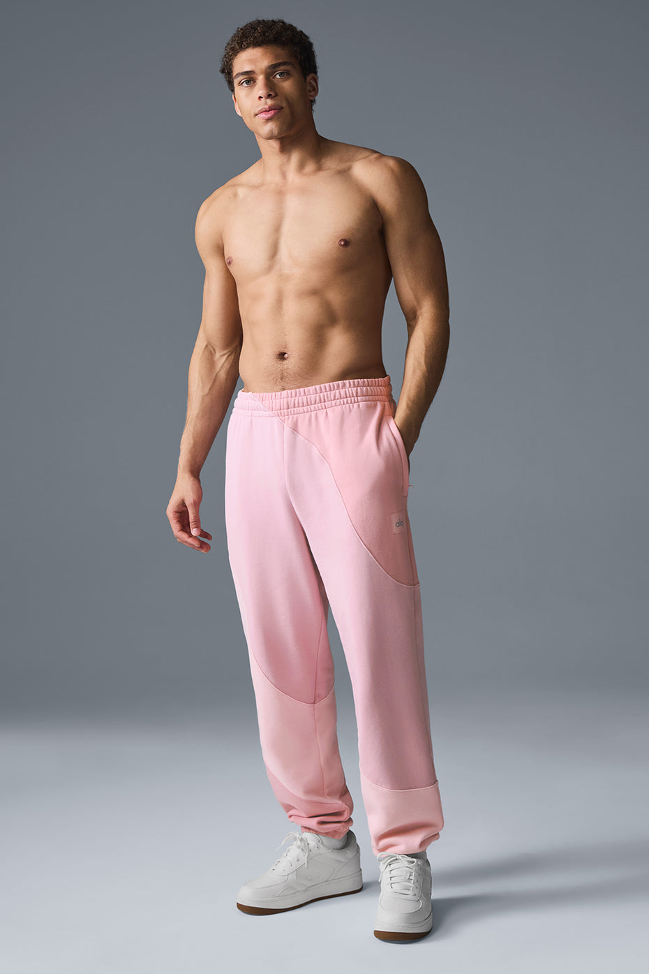 Model wearing relaxed-fit camo sweatpants with elastic cuffs