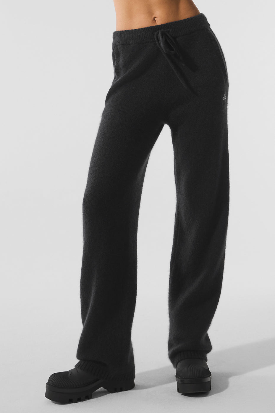 Front view of luxury sweatpants in soft black cashmere, styled with neutral flats