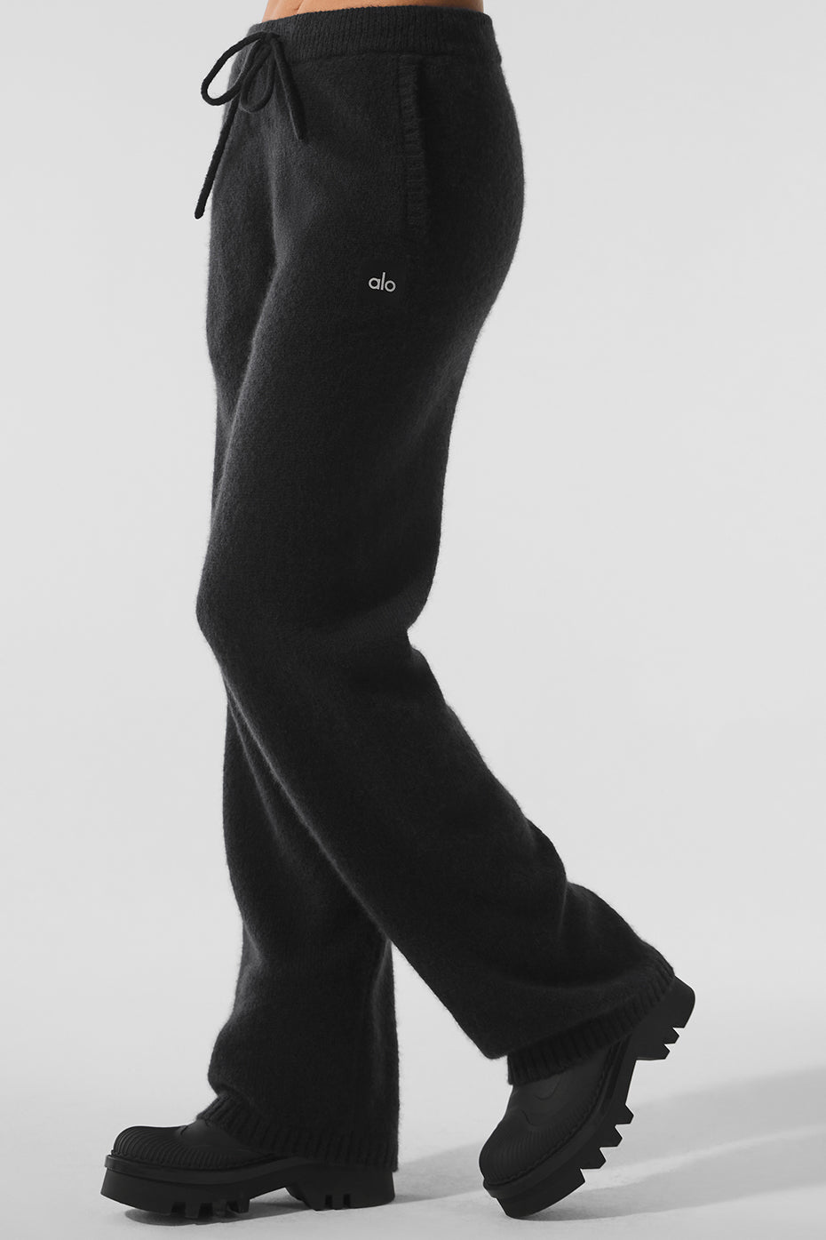 Front view of luxury sweatpants in soft black cashmere, styled with neutral flats
