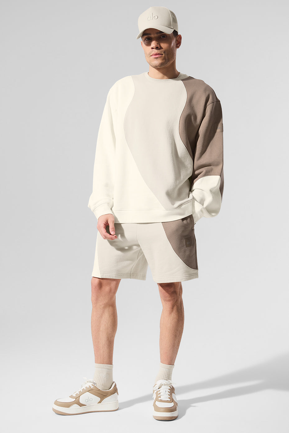 Flat lay of ivory/bone/gravel shorts paired with gym shoes and tee, suggesting activewear versatility.