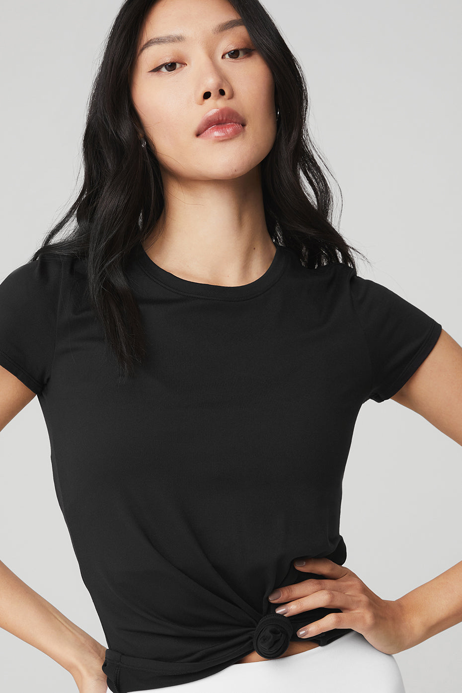 Close-up of Alosoft Finesse Tee fabric texture with yoga mat in background