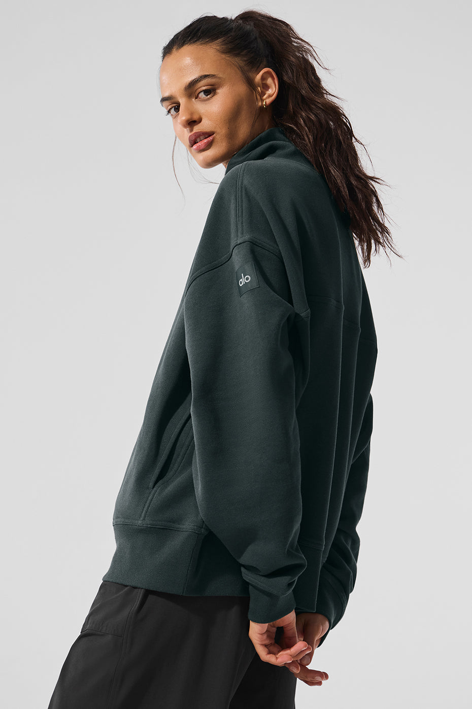 Front view of oversized turtleneck sweater styled with jeans in an urban setting.