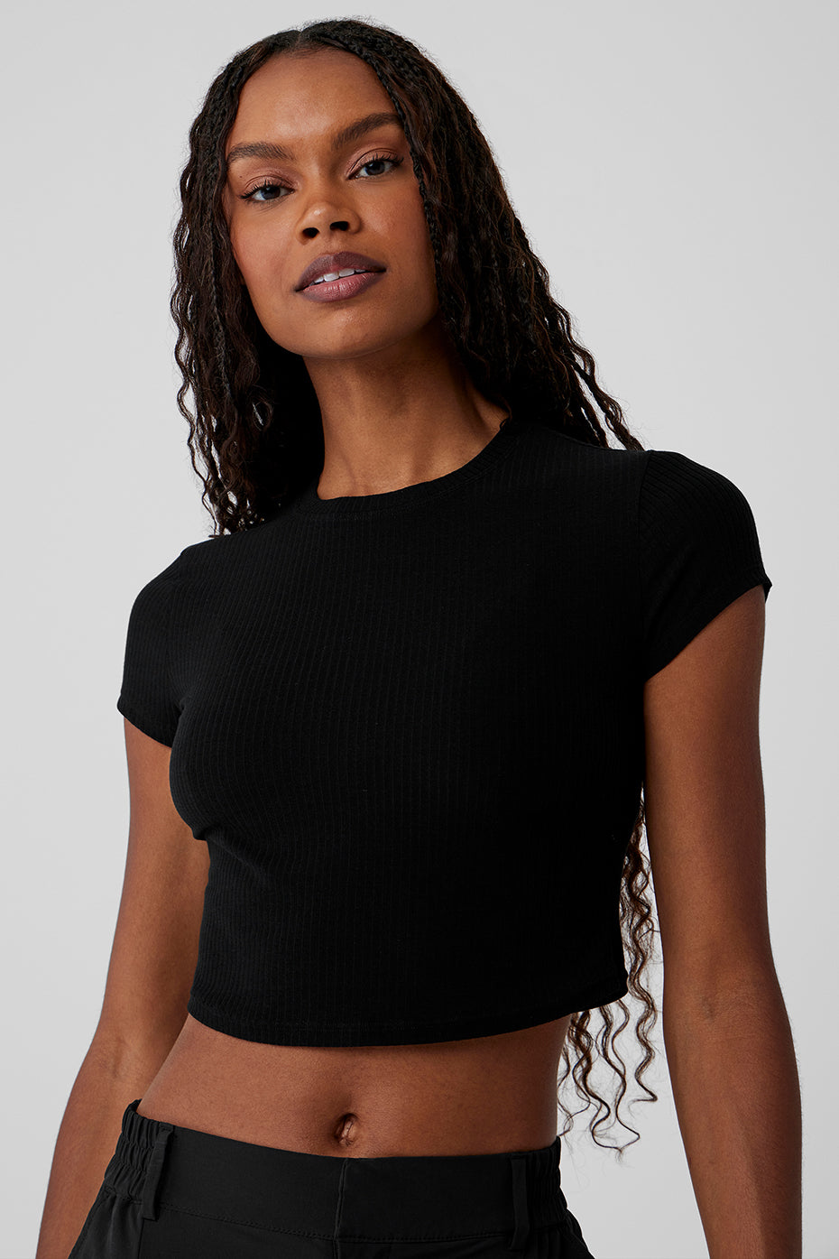 Front view of black ribbed cropped tee with cap sleeves, ideal for casual wear