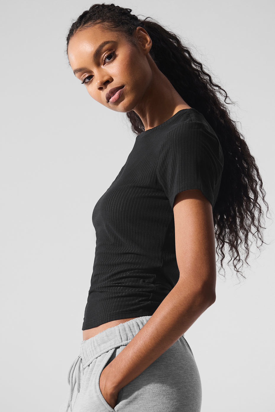 Model wearing a ribbed long sleeve tee in casual urban setting.