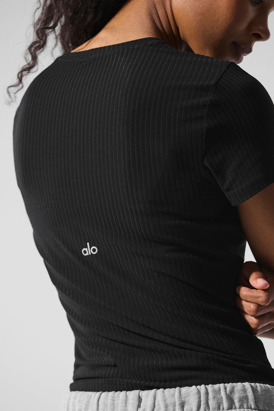 Black ribbed tee showcasing its flattering fit and style.