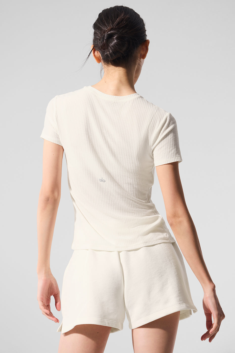 Back view of long sleeve ribbed tee paired with high-waisted denim