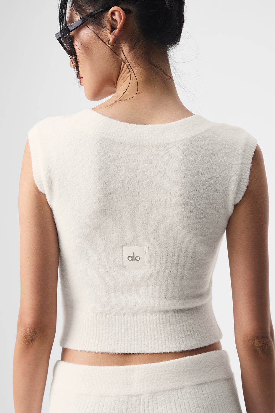 Chic ivory short sleeve sweater displayed on a hanger in a bright room.