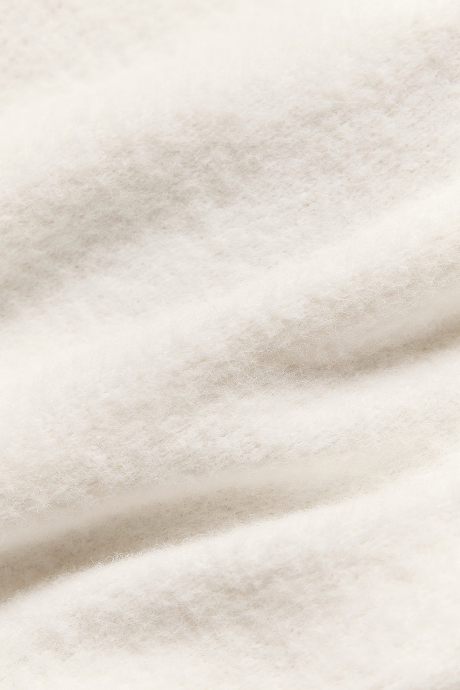 Close-up of the scooped neckline of the ivory short sleeve sweater.