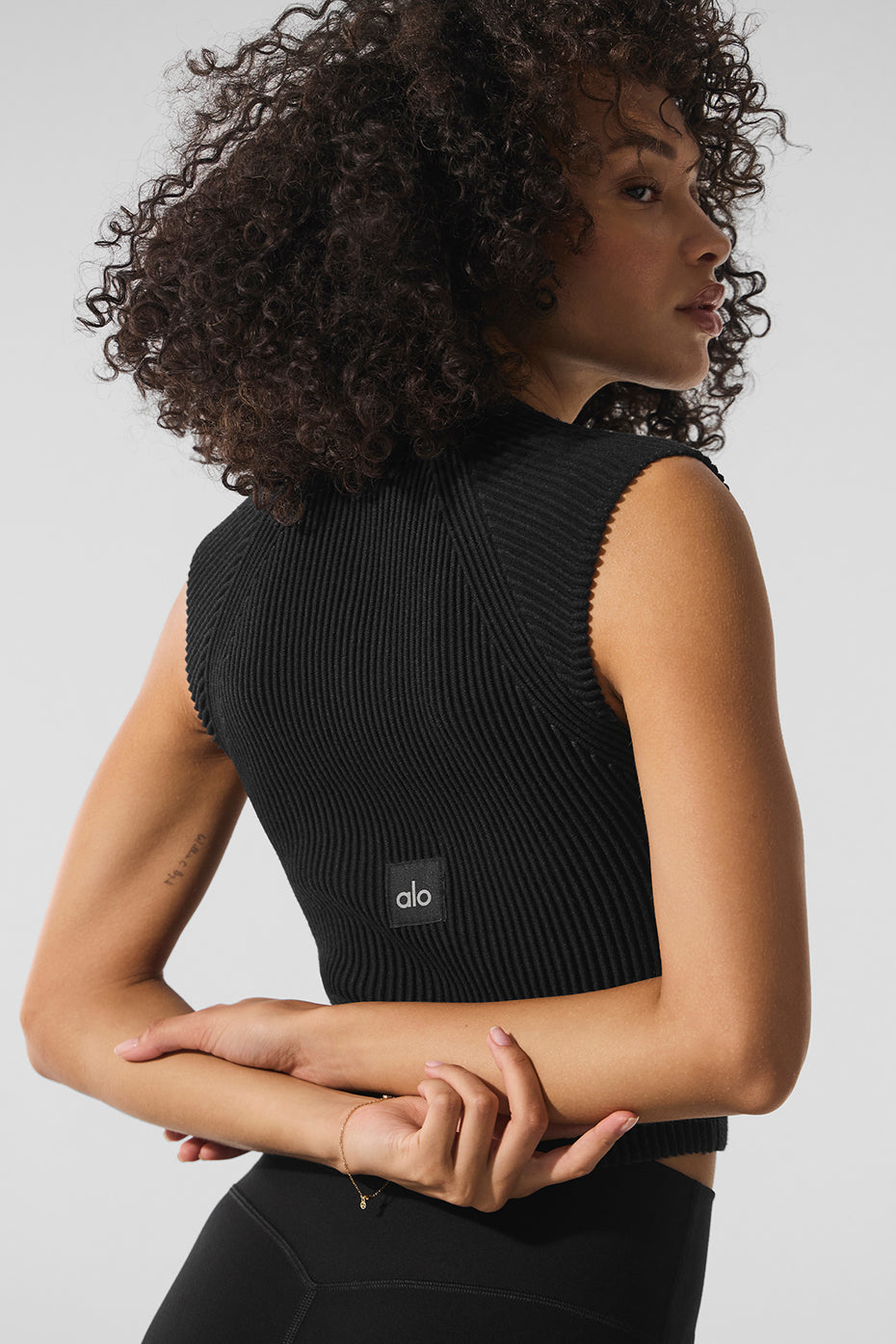 Front view of sleeveless denim halter top with full zip, worn in urban setting