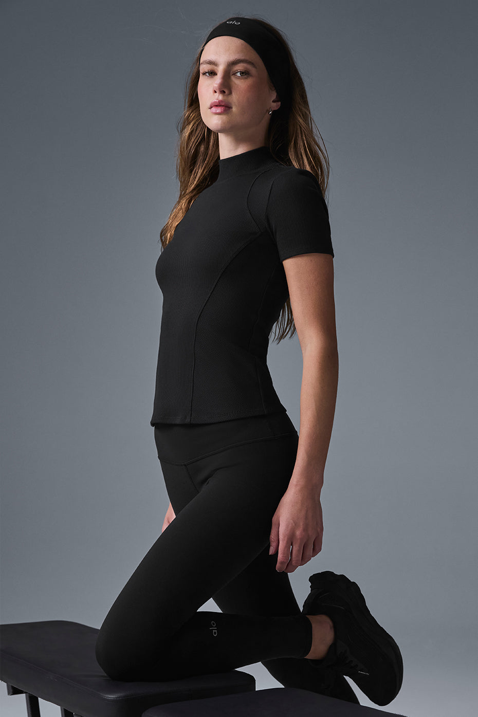 Front view of black ribbed tank top with mock neck on a model
