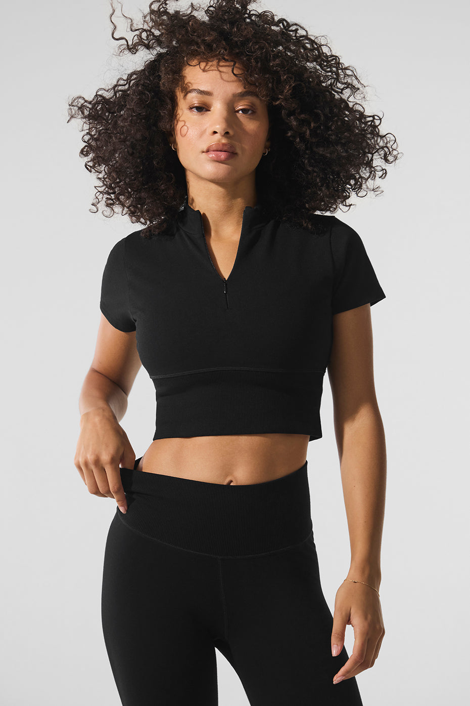 Front view of black crop top, showcasing its stylish design.