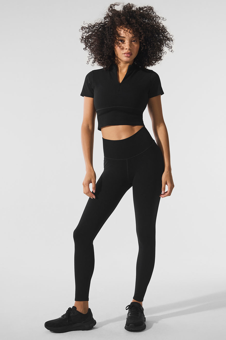 Front view of black crop top, showcasing its stylish design.