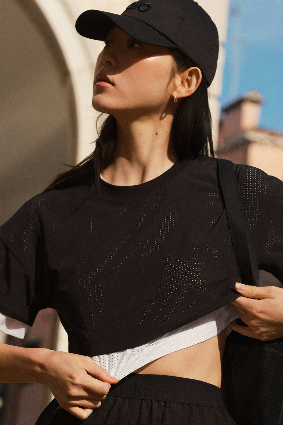 Front view of black cropped mesh top styled with high-waisted jeans