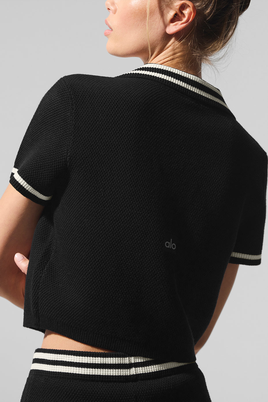 Front view of the cropped polo sweater, showcasing its structured collar and V-neckline.